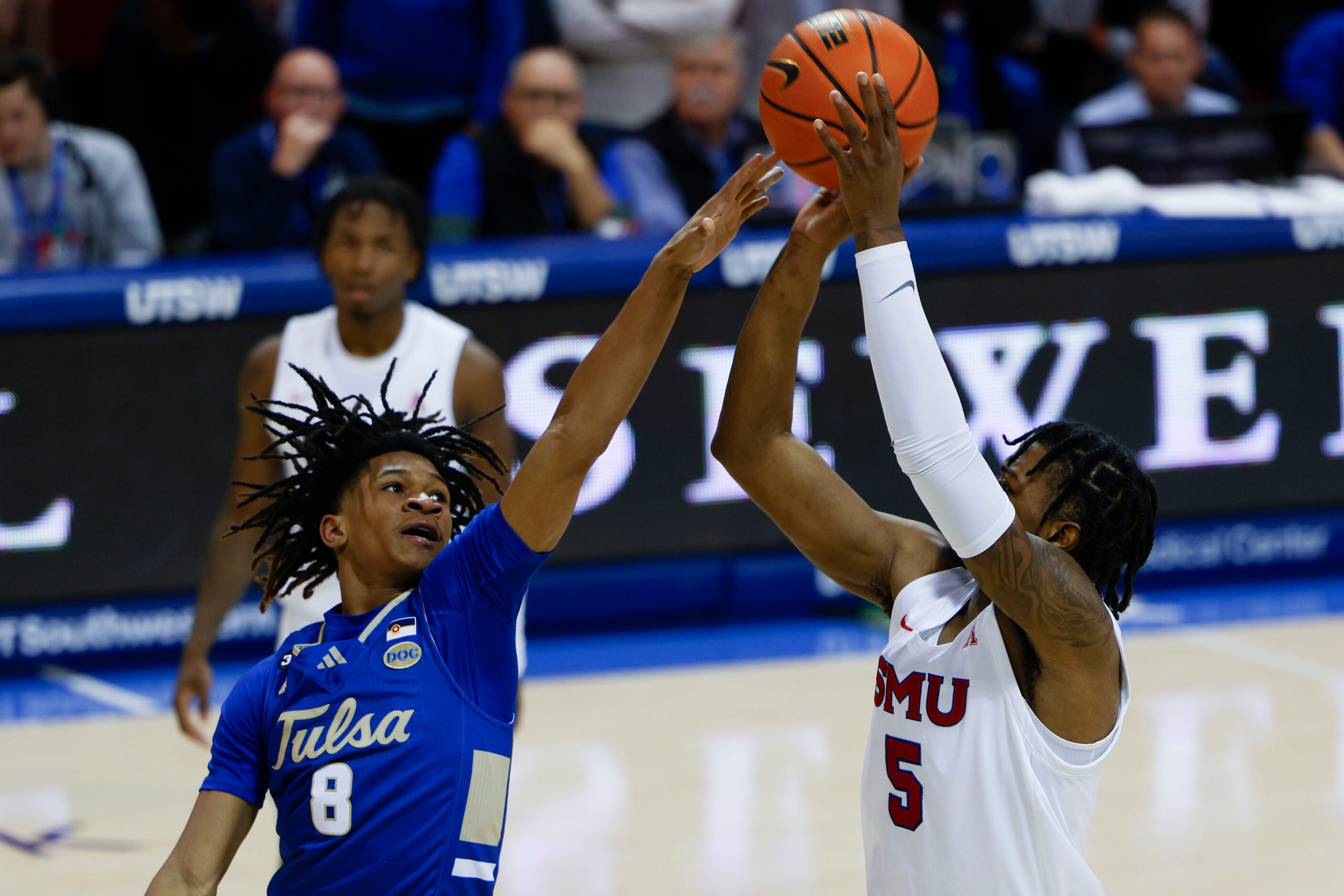 Tulsa guard Tyshawn Archie (8) reaches to block a three-pointer of Southern Methodist guard...