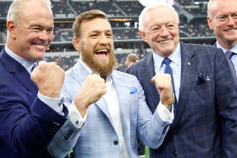 MMA fighter Conor McGregor of Ireland (second from left) throws up his fists with Stephen...