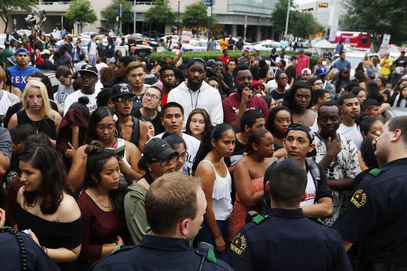  Dallas Police officers look on as crowds filled the streets outside the House of Blues in...