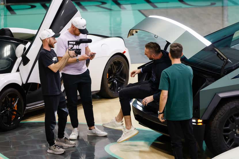 Dude Perfect’s Cody Jones (facing the camera) climbs out of a truck during a YouTube video...