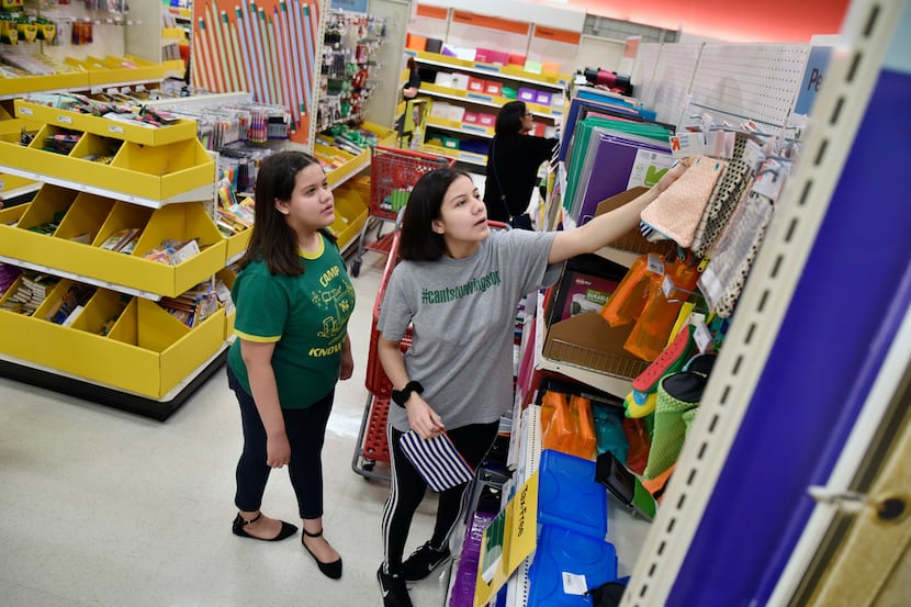 Laura Torres, 12, and her sister Vaneza Torres, 17, shop for back to school supplies during...