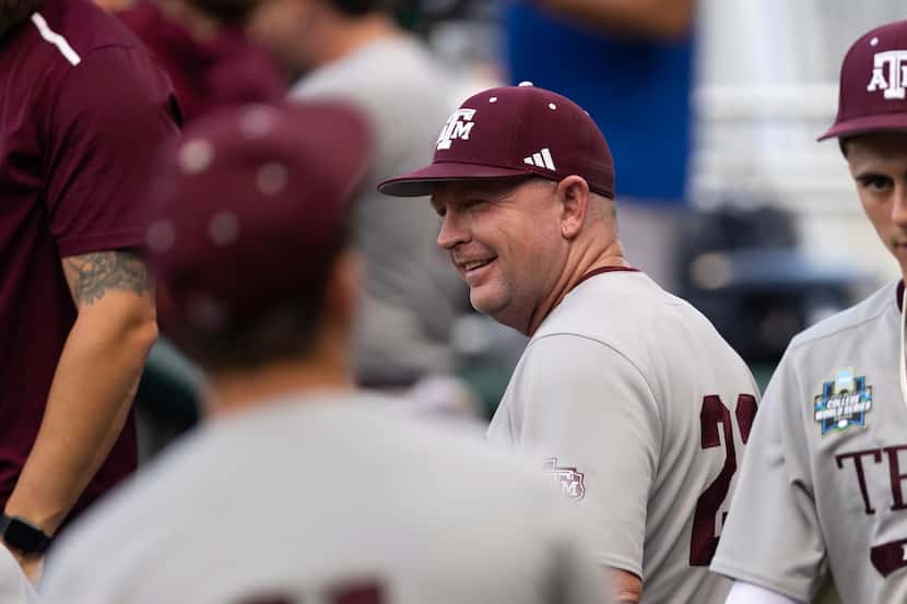 Texas A&M coach Jim Schlossnagle smiles in the dugout before his team plays against...