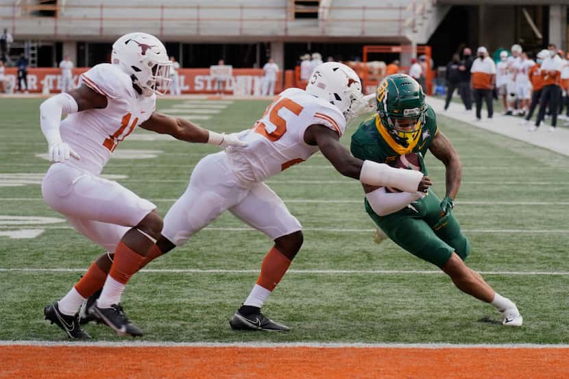 Baylor's Gavin Holmes (6) runs past Texas' B.J. Foster (25) and Anthony Cook (11) for a...