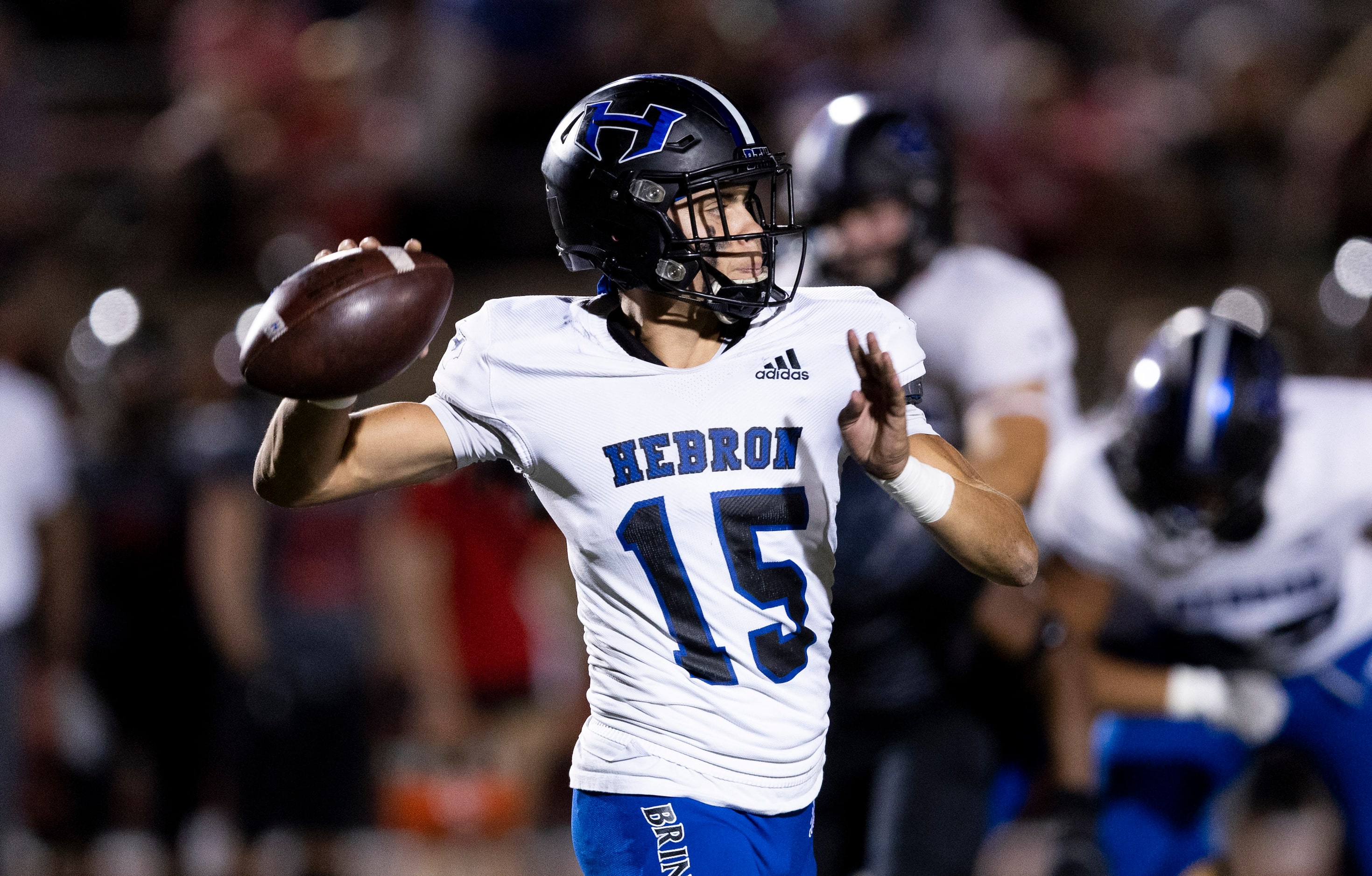 Hebron senior quarterback Braxton Baker (15) throws during the first half of a high school...