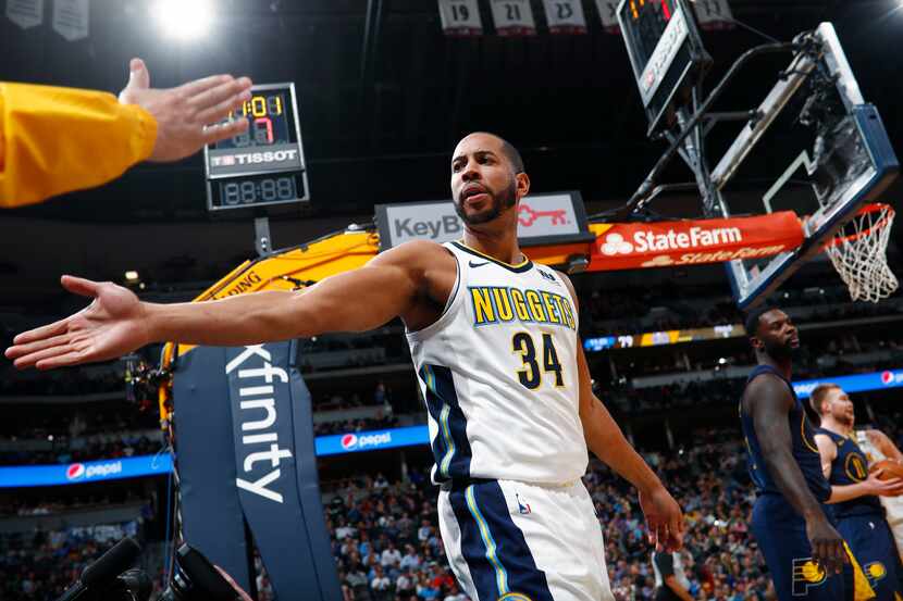 A fan reaches out to congratulate Denver Nuggets guard Devin Harris after he scored against...