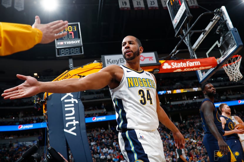 A fan reaches out to congratulate Denver Nuggets guard Devin Harris after he scored against...