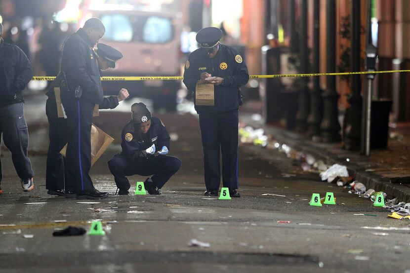 A crime scene technician collects a shell casing as New Orleans Police investigate a fatal...