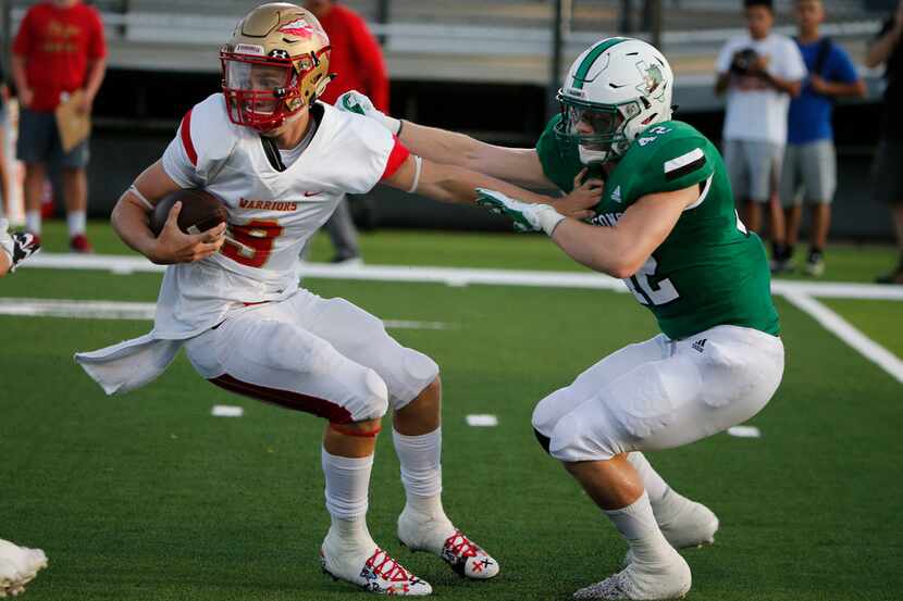 South Grand Praire quarterback Drake Logan (9) can't escape the grasp of Southlake Carroll's...