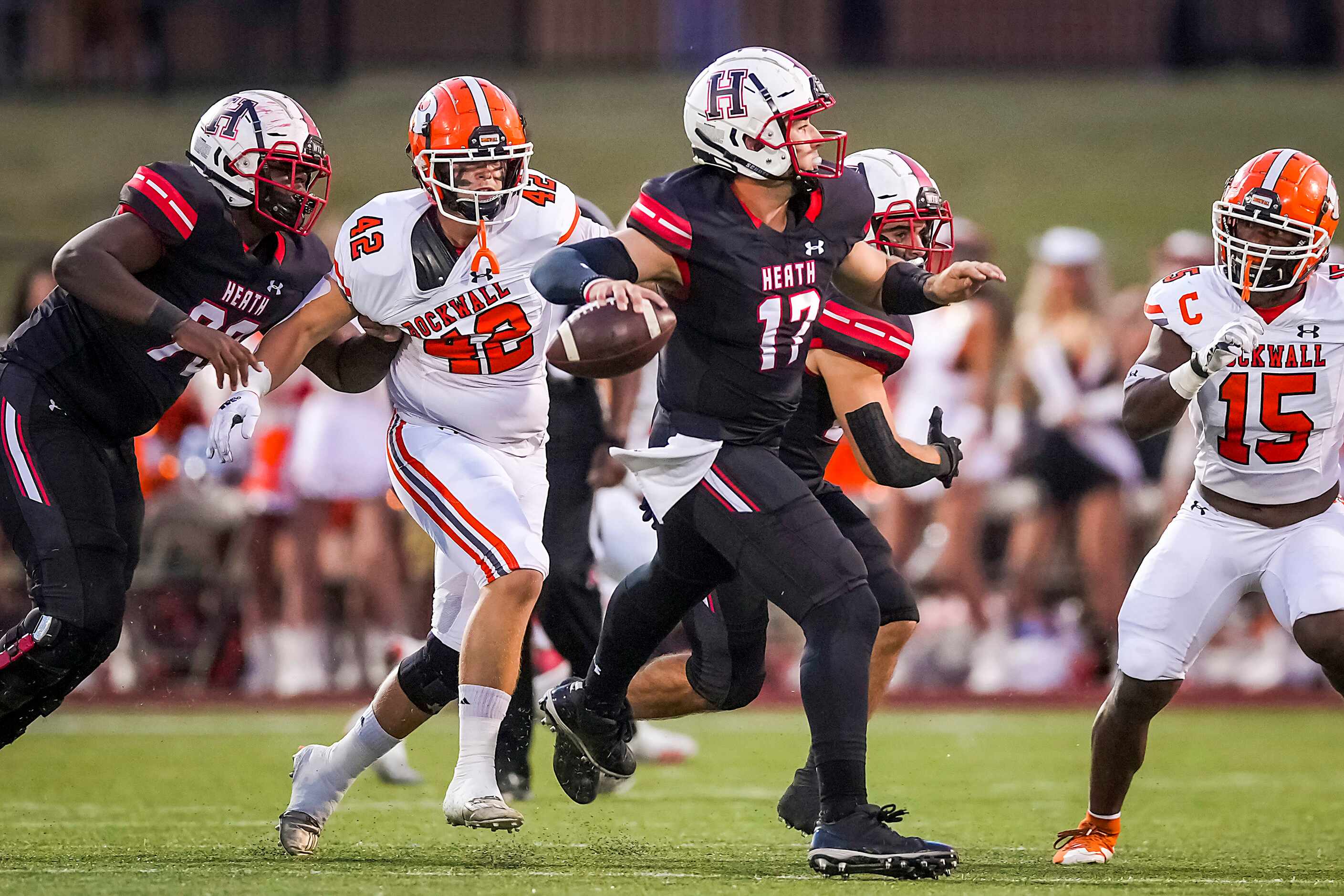 Rockwall-Heath quarterback Josh Hoover (17) scrambles away from Rockwall defensive lineman...