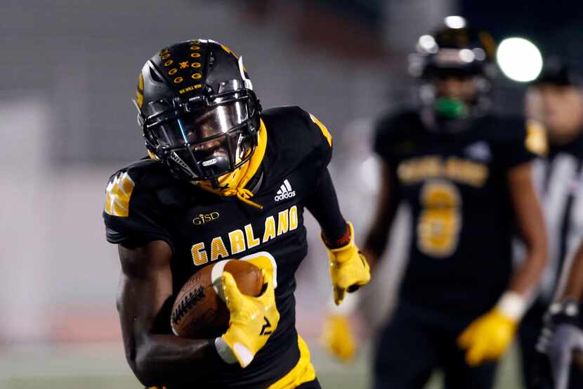 Garland’s Jordan Hudson (3) picks up a couple of yards during the first half of high school...