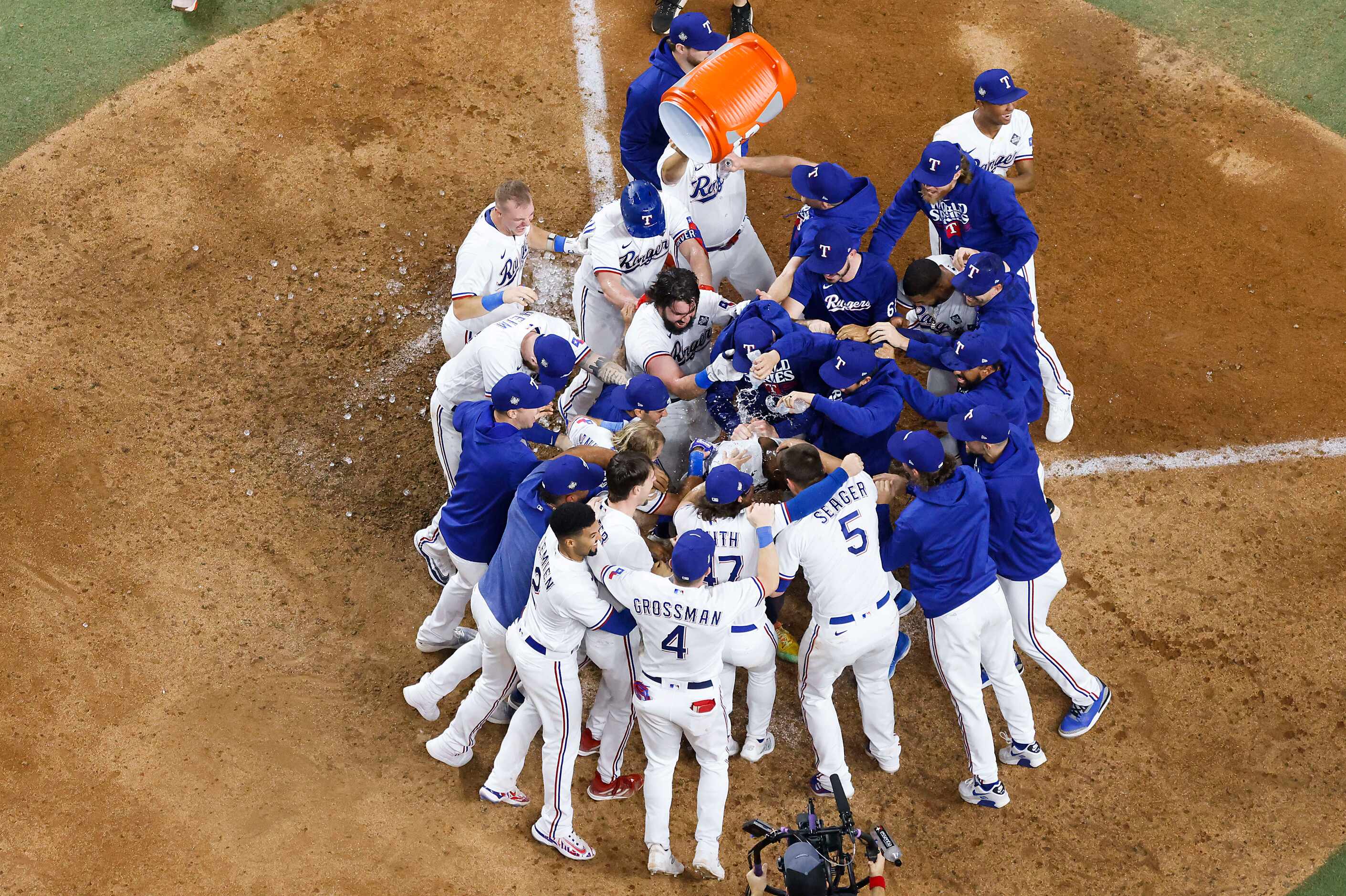 Texas Rangers right fielder Adolis Garcia is mobbed at home plate after hitting a walk-off...