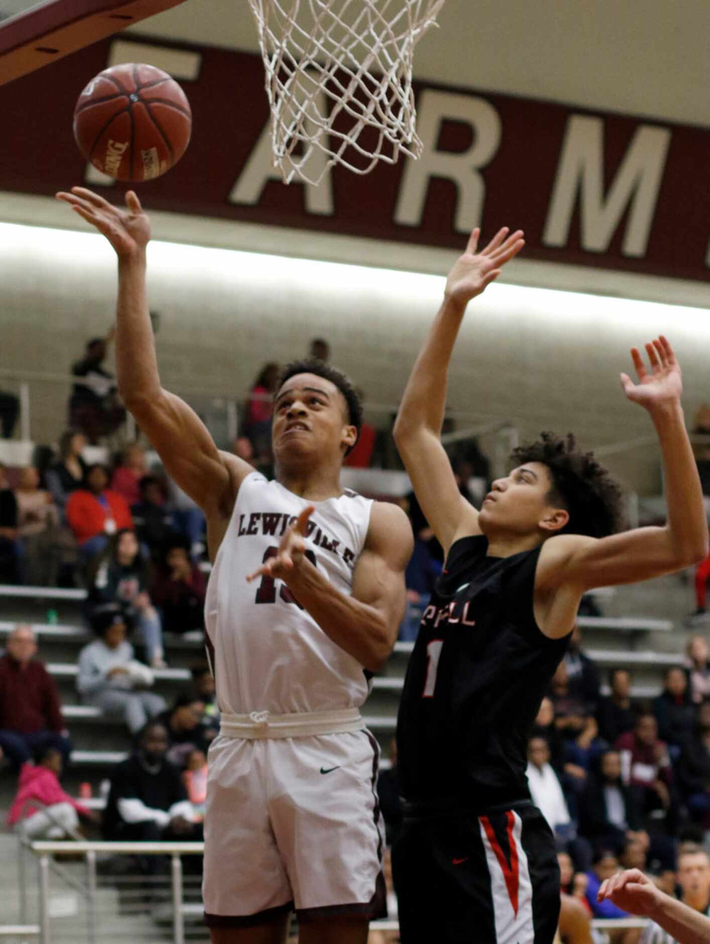 Lewisville's Tylan Dunn (13) scores over the defense of Coppell's Anthony Black (1) during...
