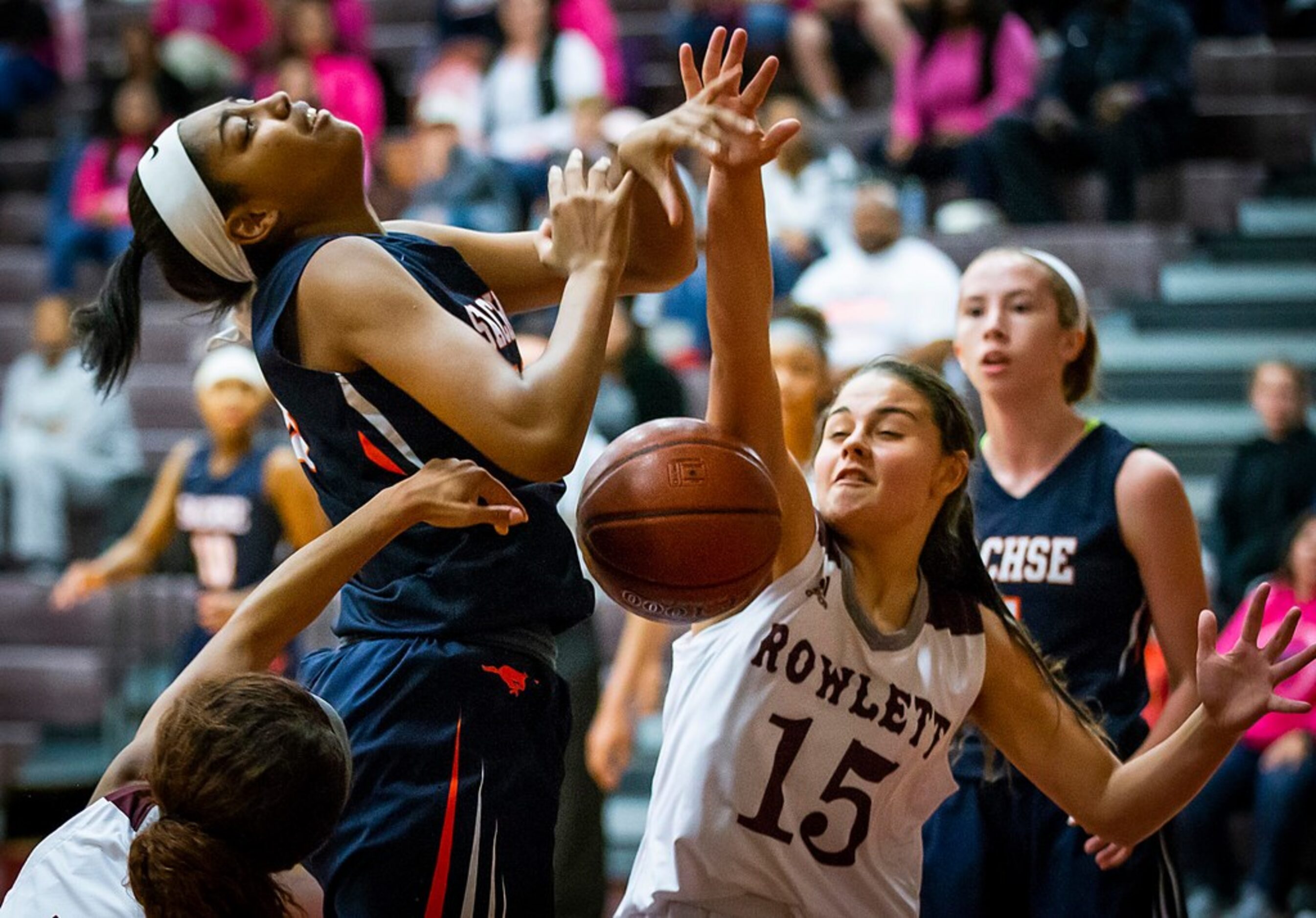 Sachse center Elizabeth Woods (33) is fouled as she tries to drive between Rowlett guards...