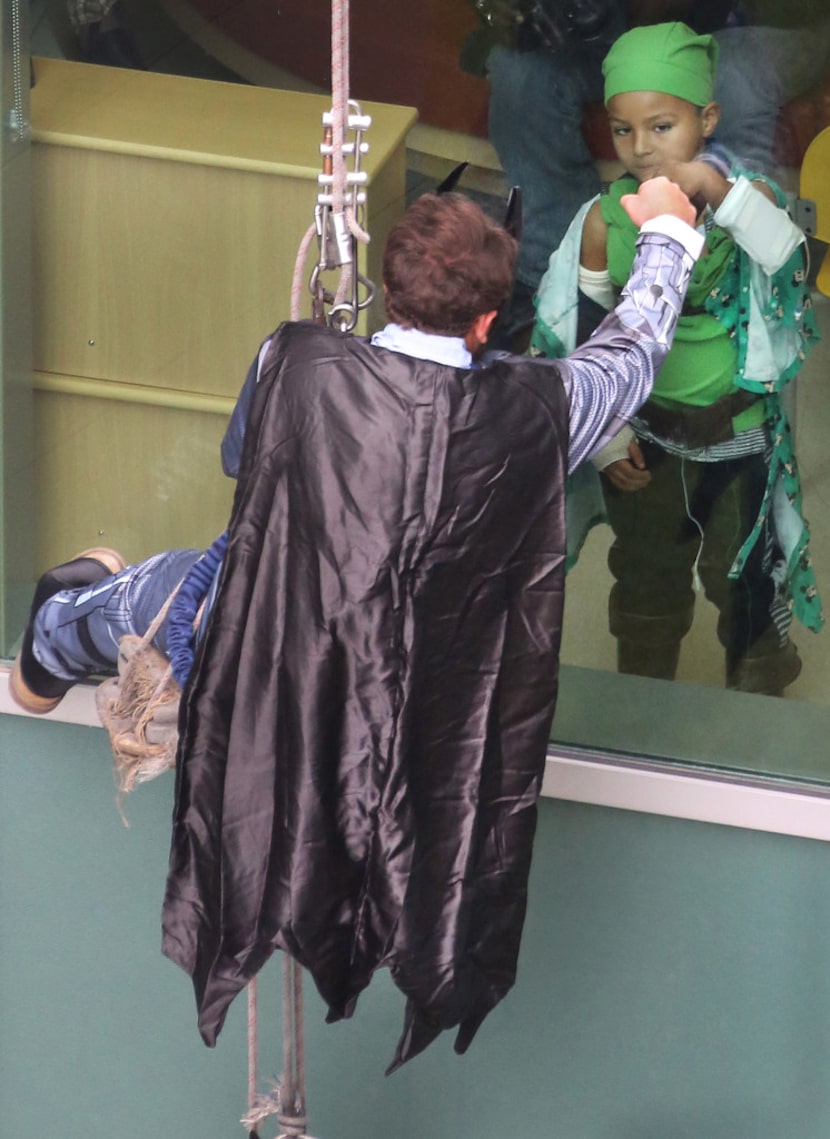 Children's Medical Center Plano patient Chrizgen Davis, right, fists bumps through the glass...