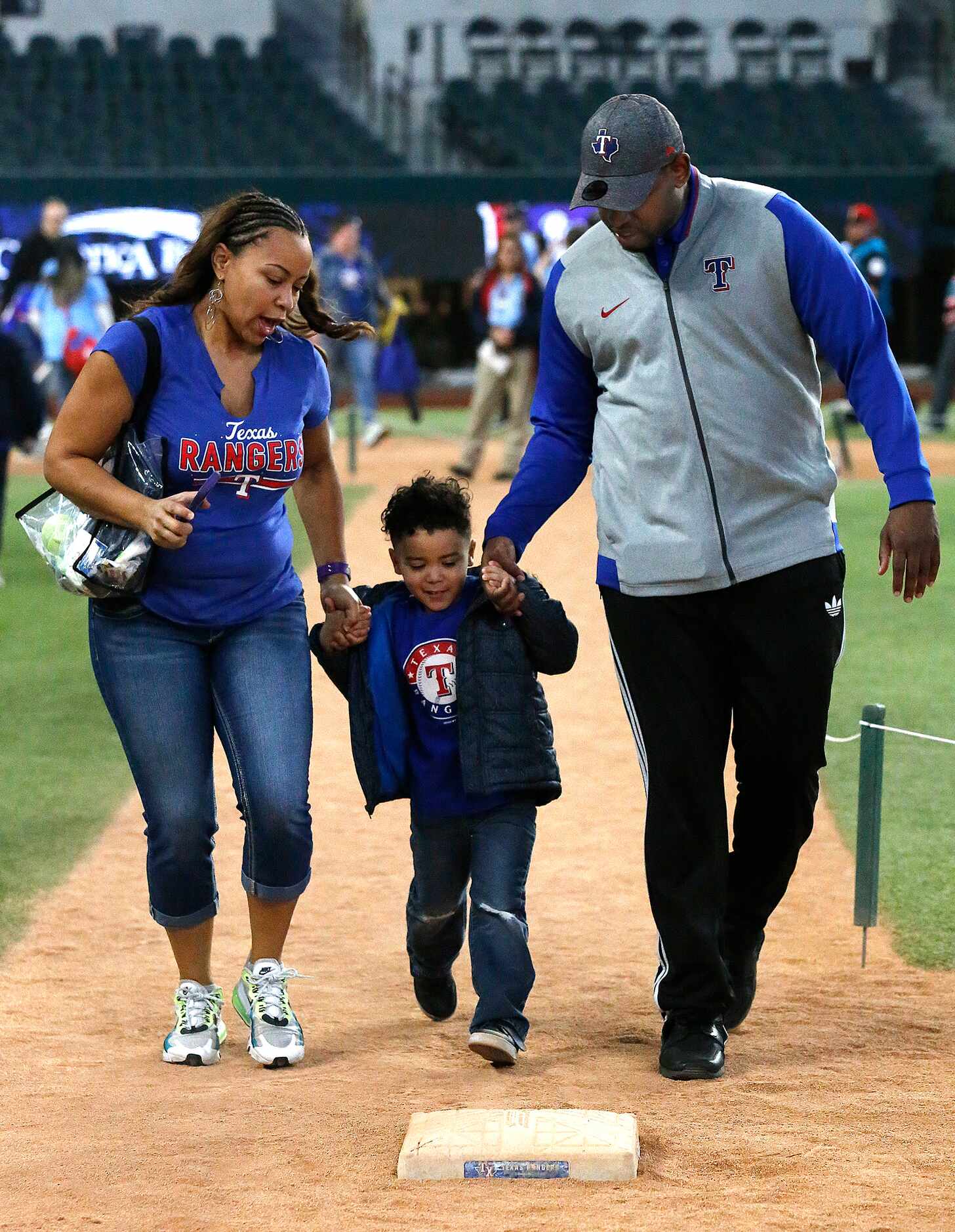 Arica Harris (left) of Fort Worth, hleps Philp Saldana (center), 3, along with J.P. Davis as...