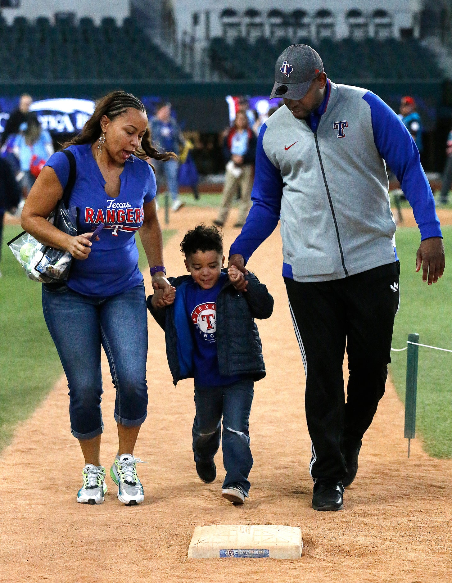 Arica Harris (left) of Fort Worth, hleps Philp Saldana (center), 3, along with J.P. Davis as...