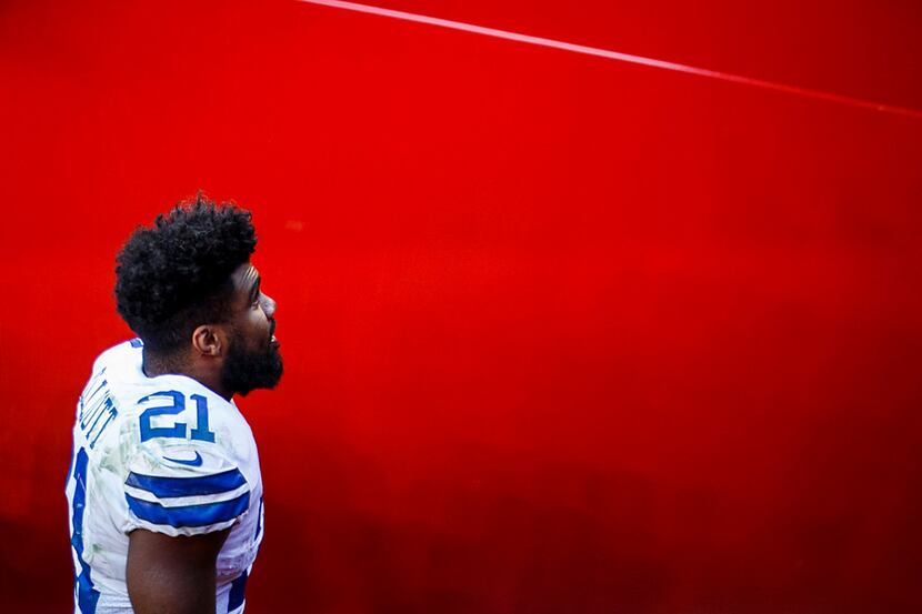 Dallas Cowboys running back Ezekiel Elliott looks up at the crowd as he leaves the field...