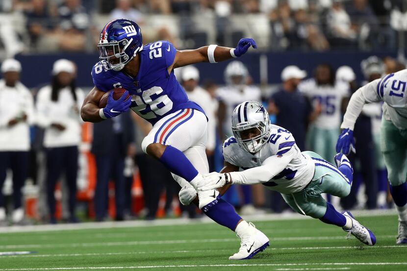 ARLINGTON, TEXAS - SEPTEMBER 08:  Saquon Barkley #26 of the New York Giants is tackled by...