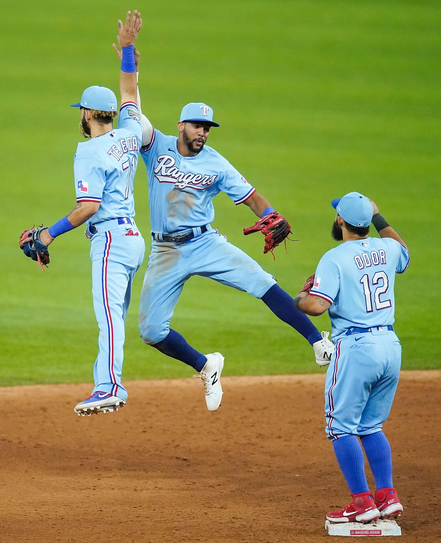 Texas Rangers center fielder Leody Taveras celebrates with shortstop Anderson Tejeda and...