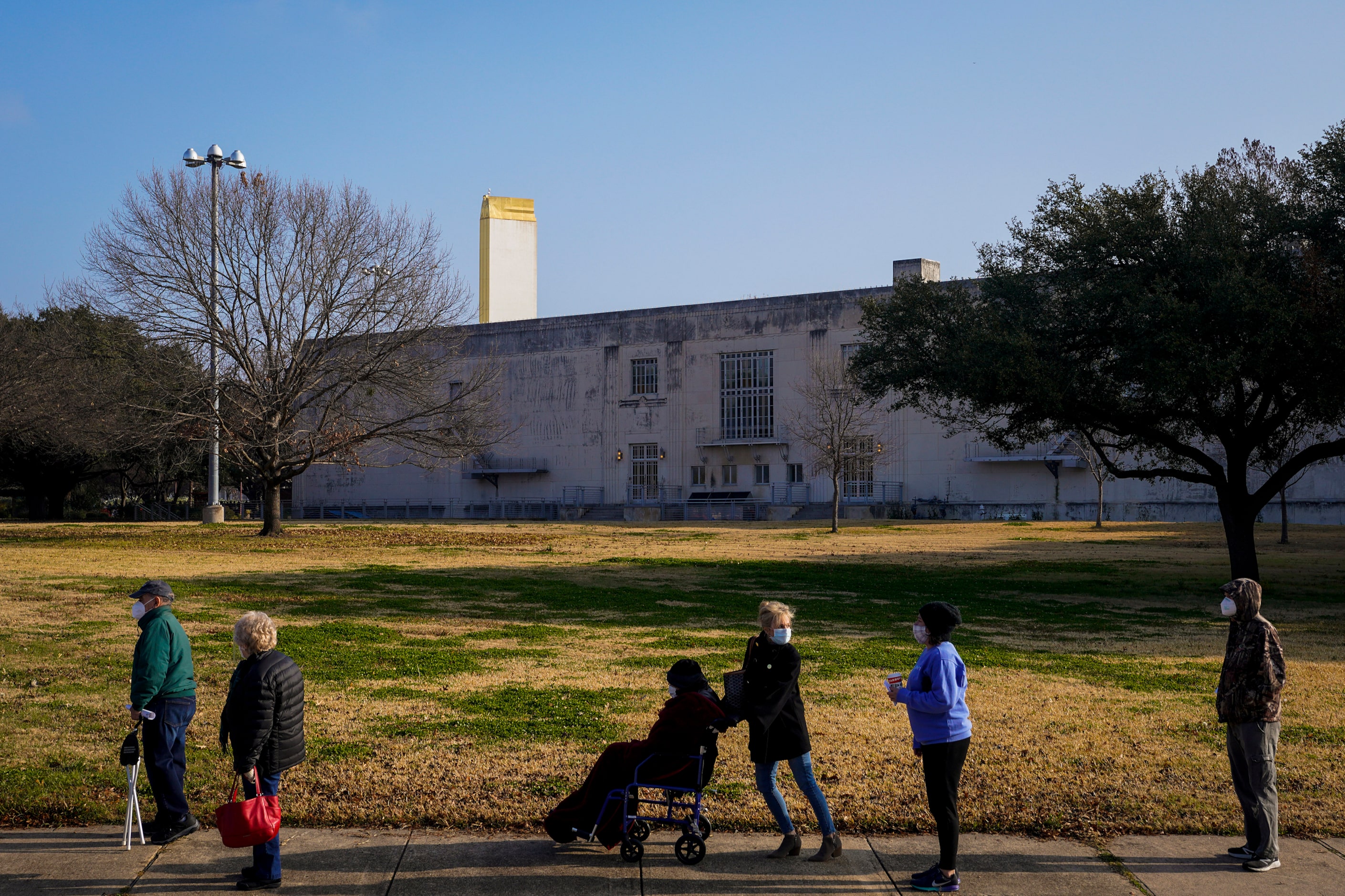 People wait in a long line to receive the COVID-19 vaccine at Fair Park on Monday, Jan. 11,...