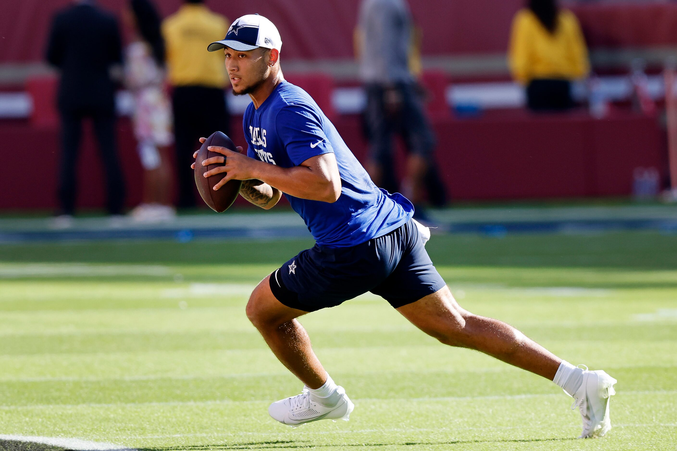 Dallas Cowboys quarterback Trey Lance (15) rolls out during pregame warmups before the team...