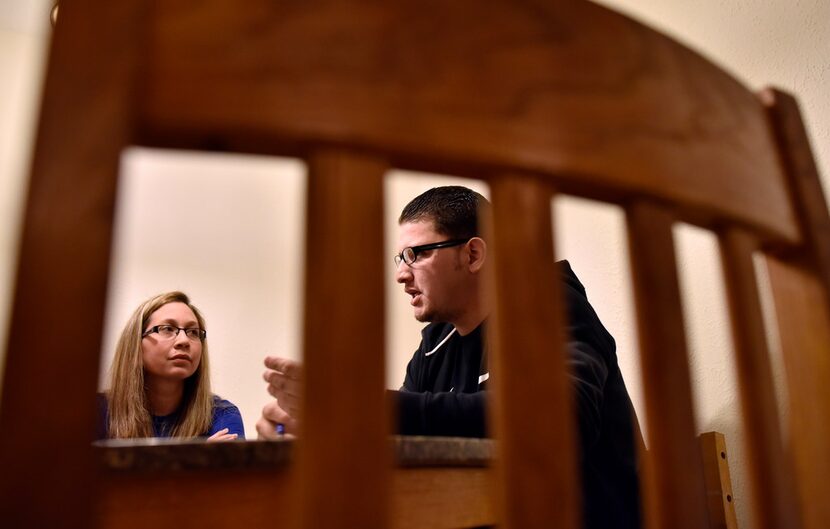 Maria Sosa, left, and her husband Ronald Cedeño speak at their kitchen table at their...