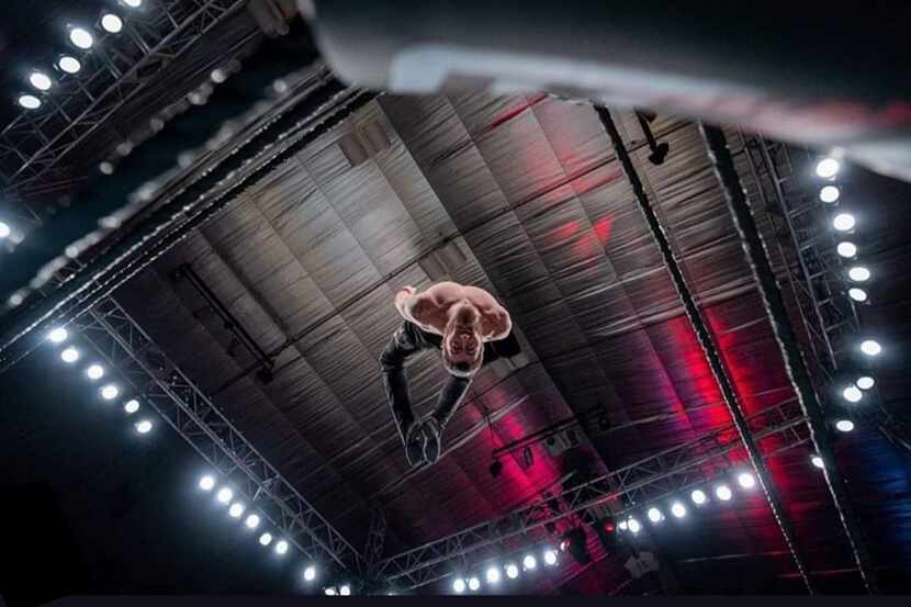 Professional wrestler Chandler Hopkins dives onto Low Ki (not pictured) during a Major...