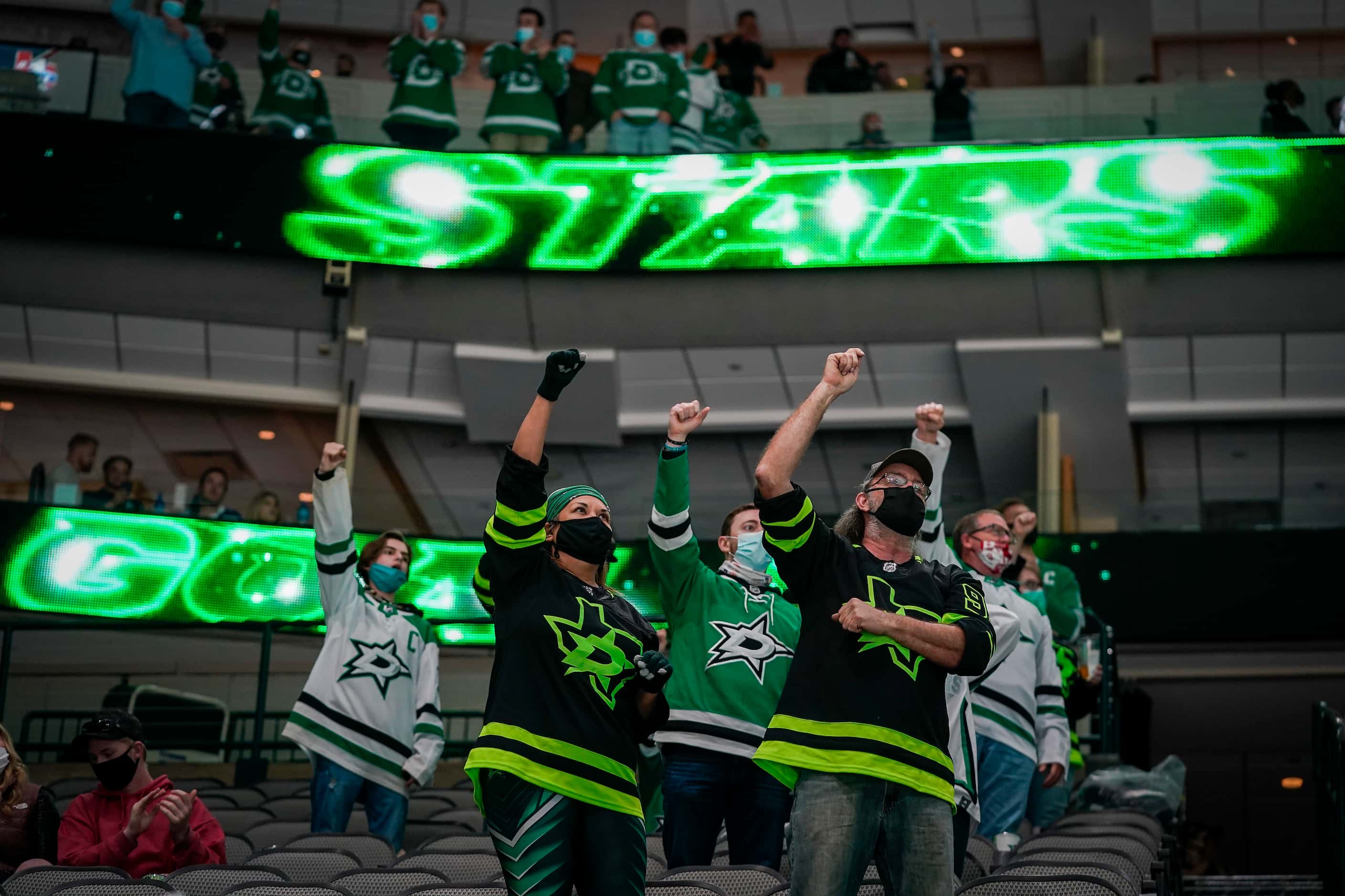 Dallas Stars fans cheer after a power play goal to tie the game during the second period of...