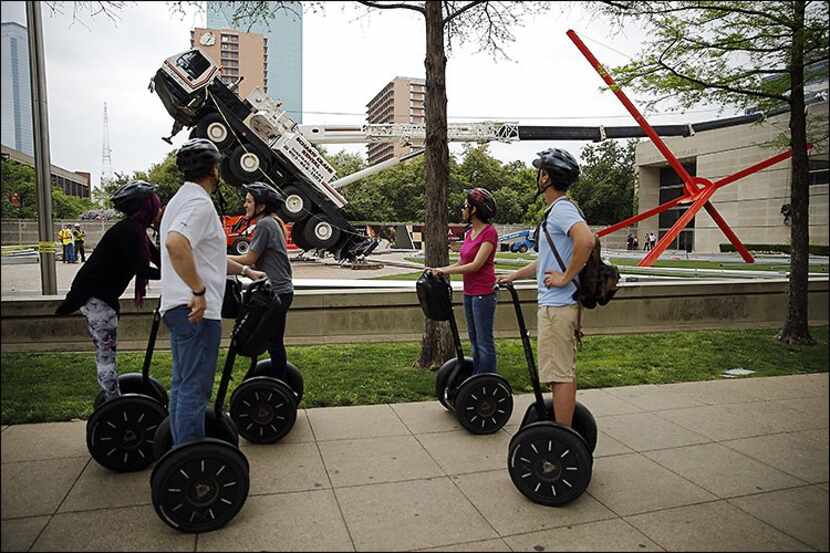 
Riders on a Segway tour stopped to view a collapsed crane in front of the Dallas Museum of...