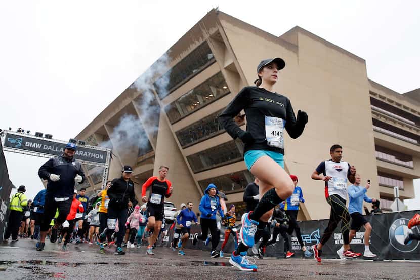 Runners sprint from the start past City Hall in the 2018 BMW Dallas Marathon 5K race in...
