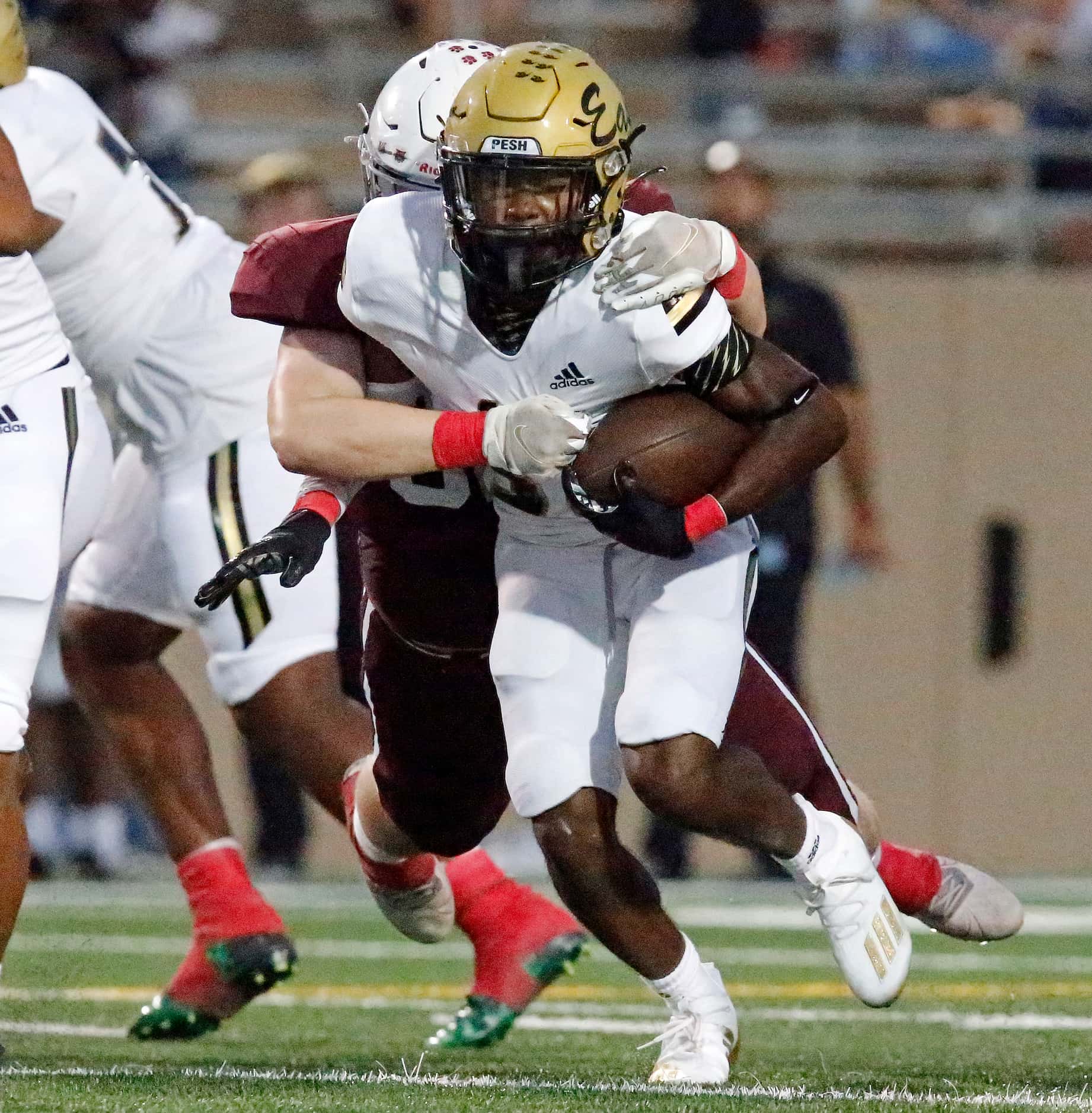 Plano East High School running back Jordan Yearby (30) slips through the tackle of  Plano...