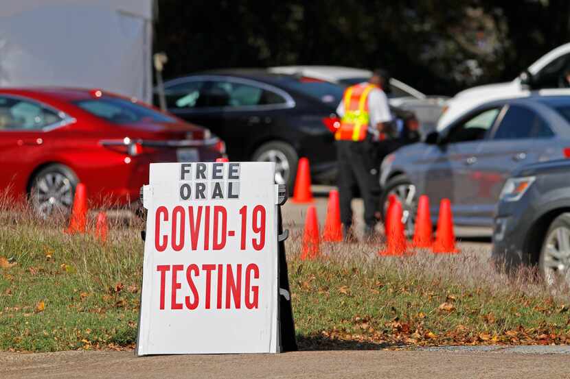 Cars wait in line to receive a COVID-19 oral testing kit at the Good Street Baptist Church...