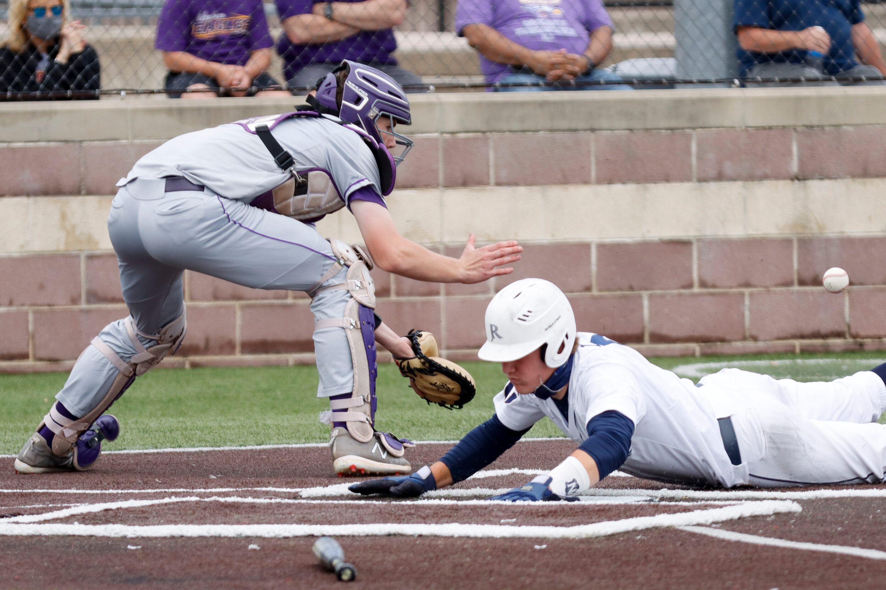 Jesuit’s David Long slides safely home to score a run ahead of Richardson catcher Marcus...