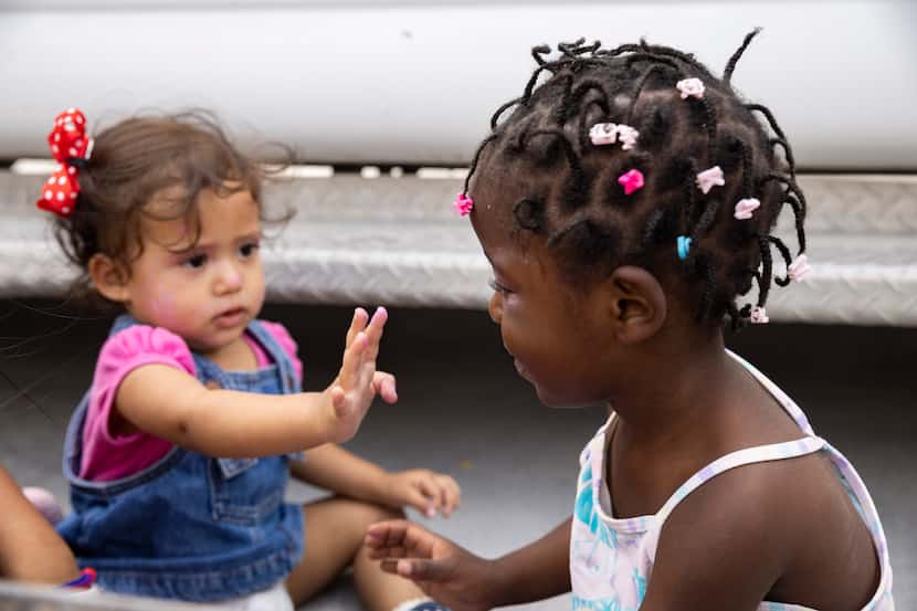 Daniela Martínez, de 1 año, y  Louvenjuna Elien, 4, juegan