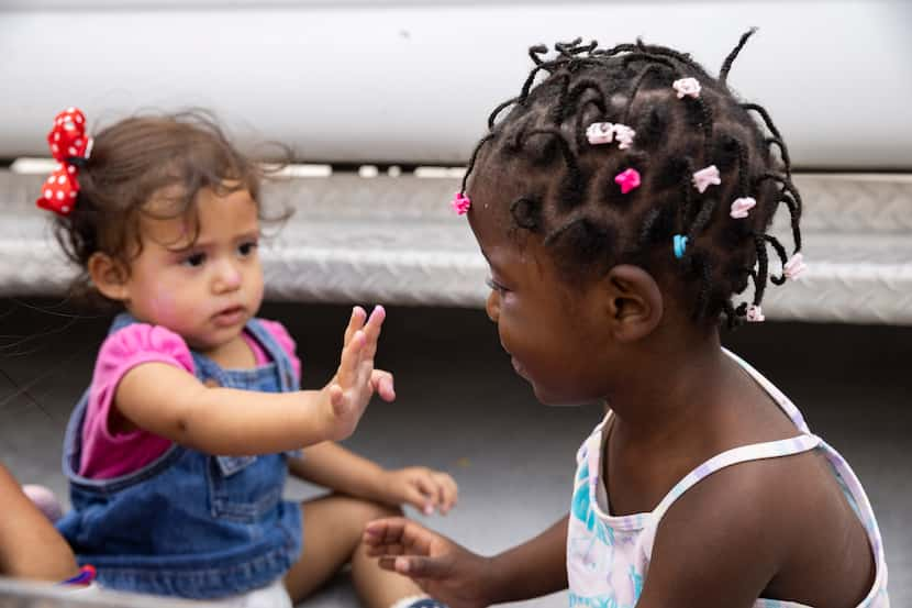 Daniela Martinez, 1, left, and Louvenjuna Elien, 4, try on makeup at Senda de Vida shelter...