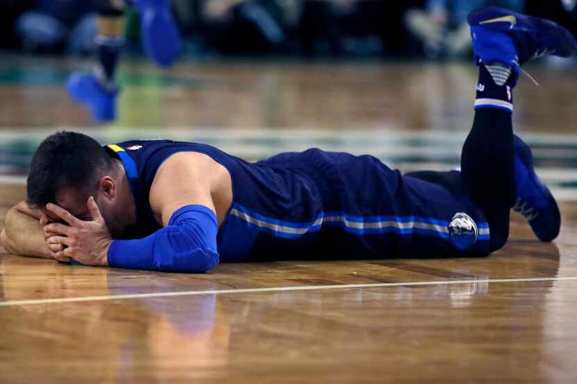 Dallas Mavericks guard J.J. Barea (5) drops to the floor after an apparent injury during the...