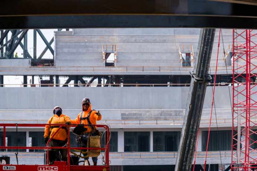 Obradores de construcción trabajando en el nuevo estadio de béisbol Globe Life Field de los...