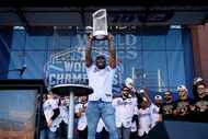 Texas Rangers right fielder Adolis Garcia hoists the Commissioner’s Trophy during a ceremony...