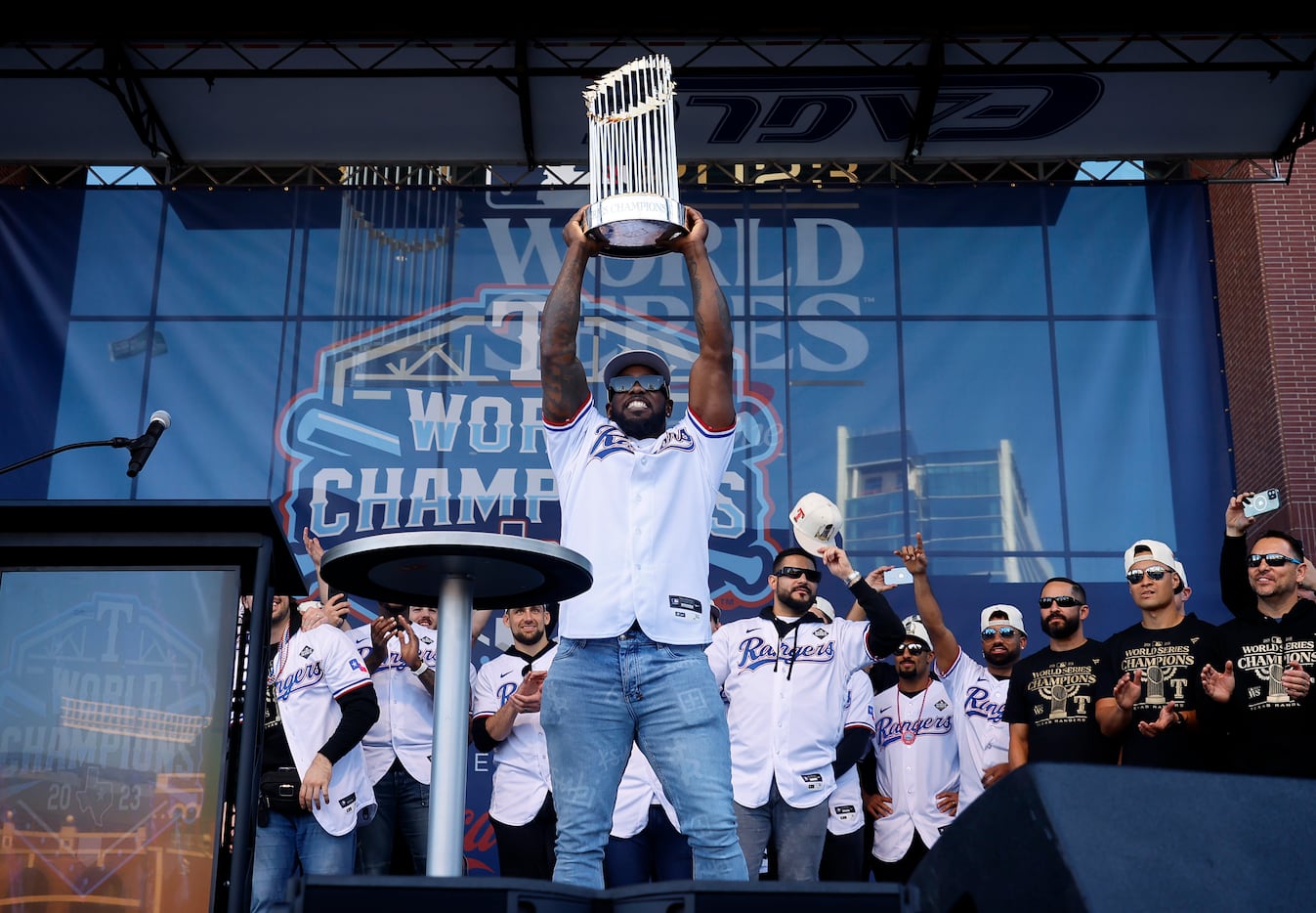 Texas Rangers right fielder Adolis Garcia hoists the Commissioner’s Trophy during a ceremony...