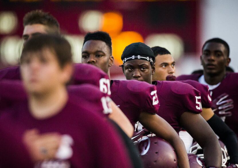 Ennis High School football players line up for the national anthem before their game against...