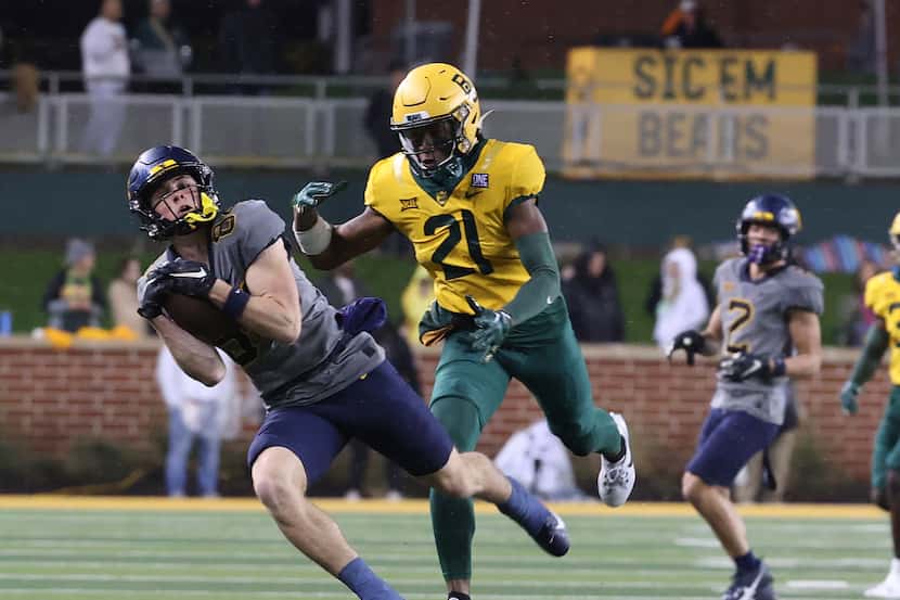 West Virginia wide receiver Hudson Clement, left, catches a pass over Baylor cornerback...