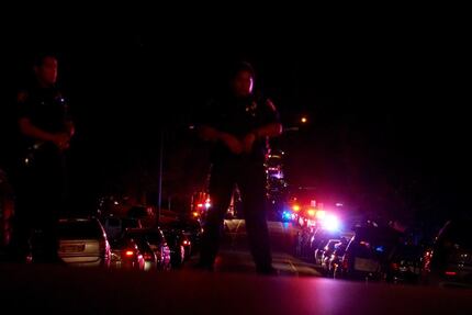 Police officers block the street at the scene where two officers were shot in the Wedgwood...