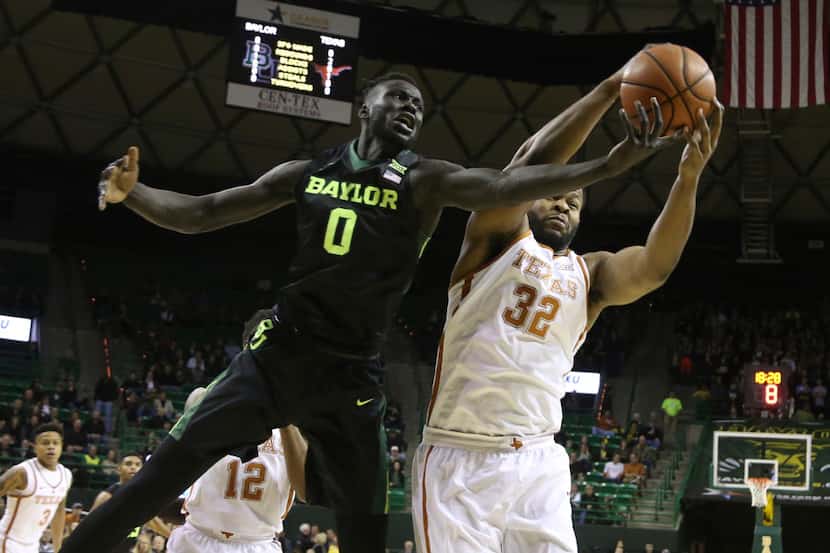 Texas forward Shaquille Cleare, right, pulls down a rebound over Baylor forward Jo...