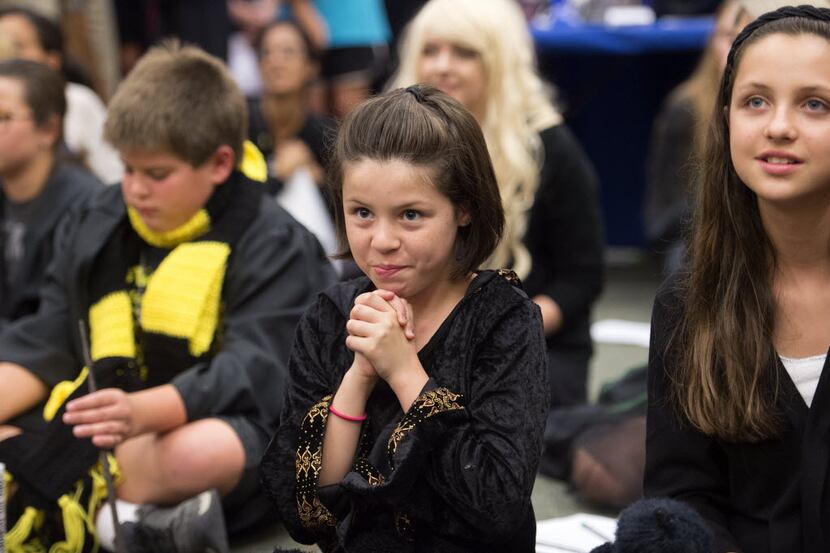 Sofia Martinez, 9, center, and her sister Lilian Martinez, 12, right, await the results of a...