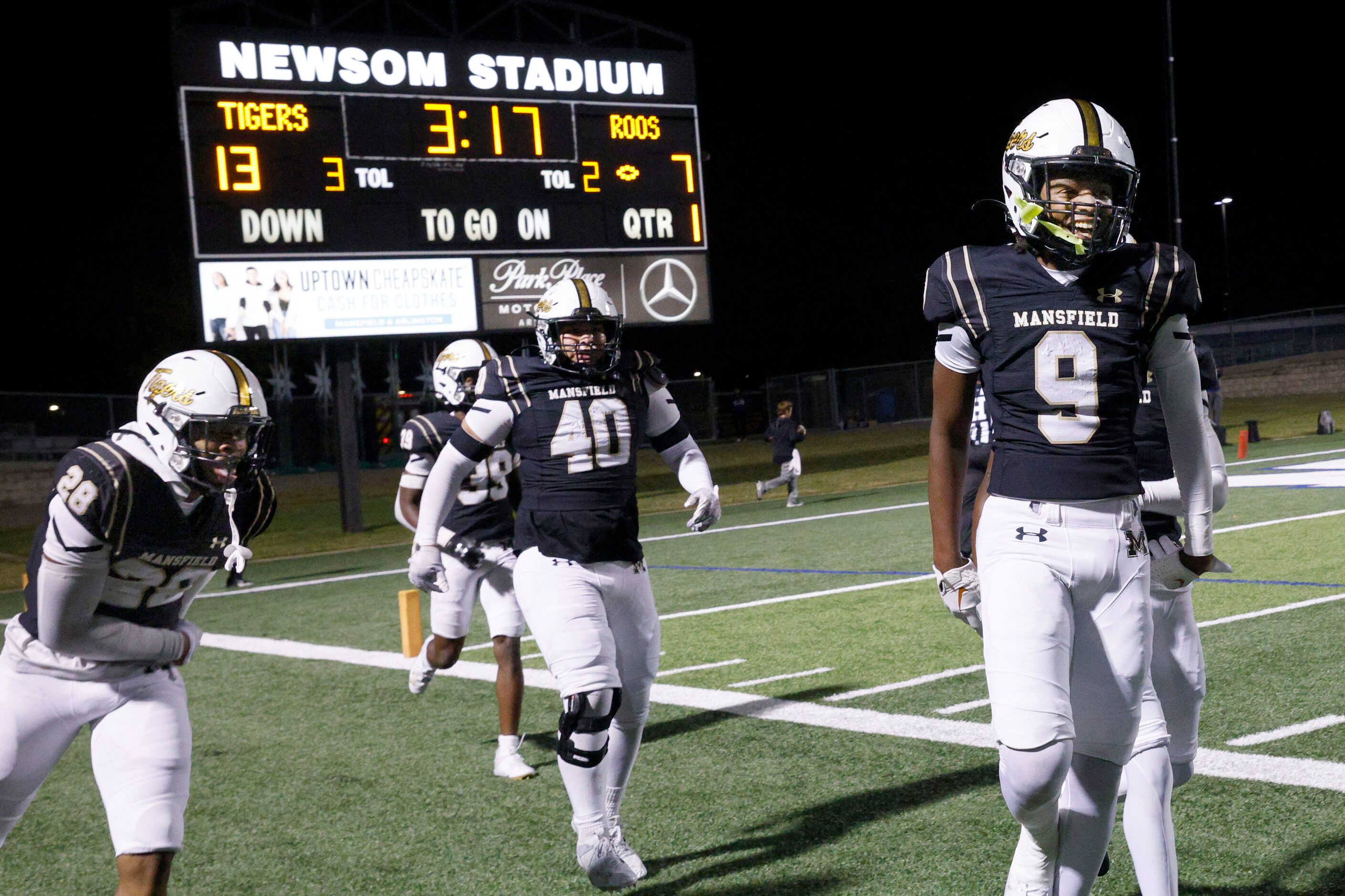 Mansfield's Zavyj Jenkins (9) celebrates with his teammates after scoring a touchdown in the...