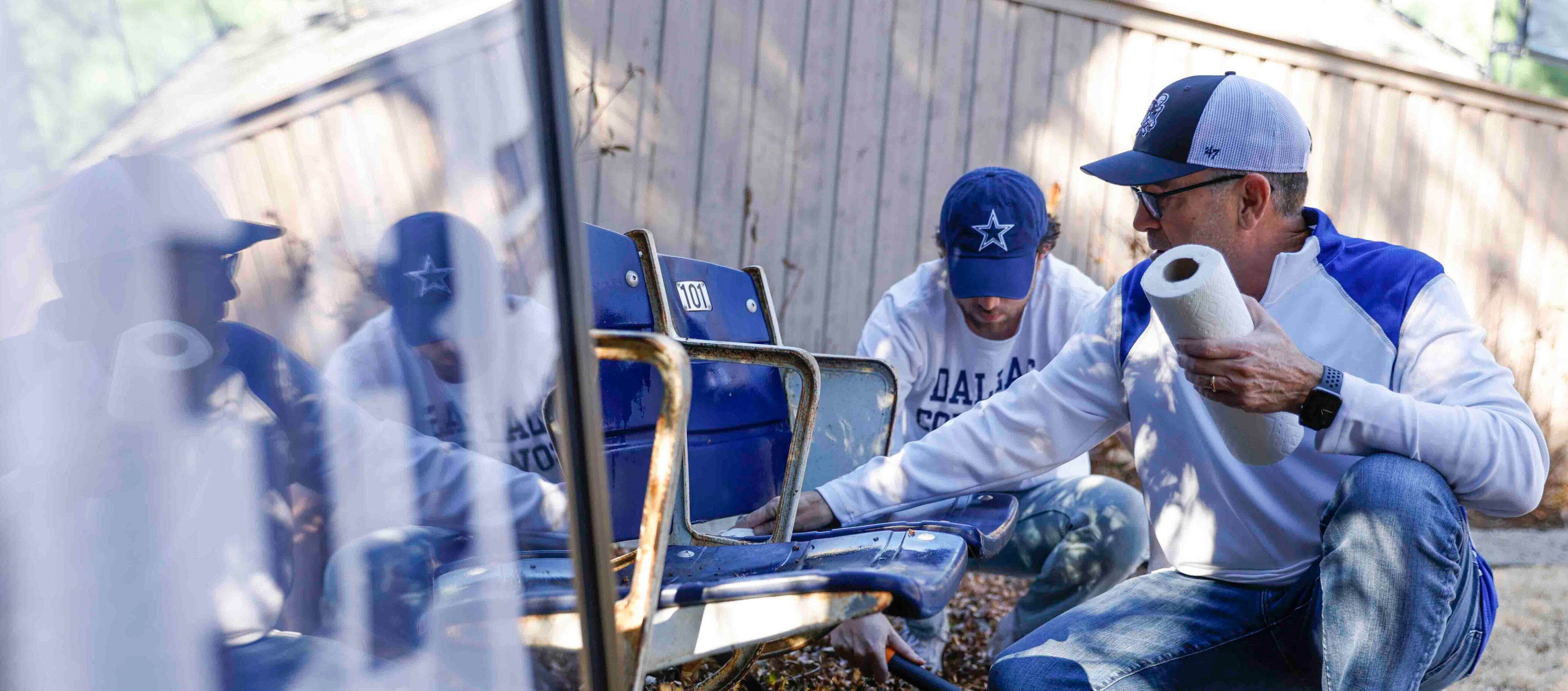 Marc, front, and Miles Andres clean the seats that they bought from the old Cowboys stadium...