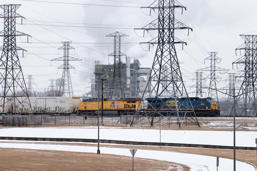A CSX and Union Pacific train passes by the Handley Generating Station in East Fort Worth,...