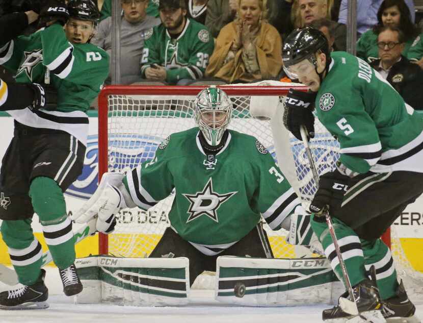 Dallas goalie Kari Lehtonen (32) keeps his eyes on the puck (near his left pad) as teammates...