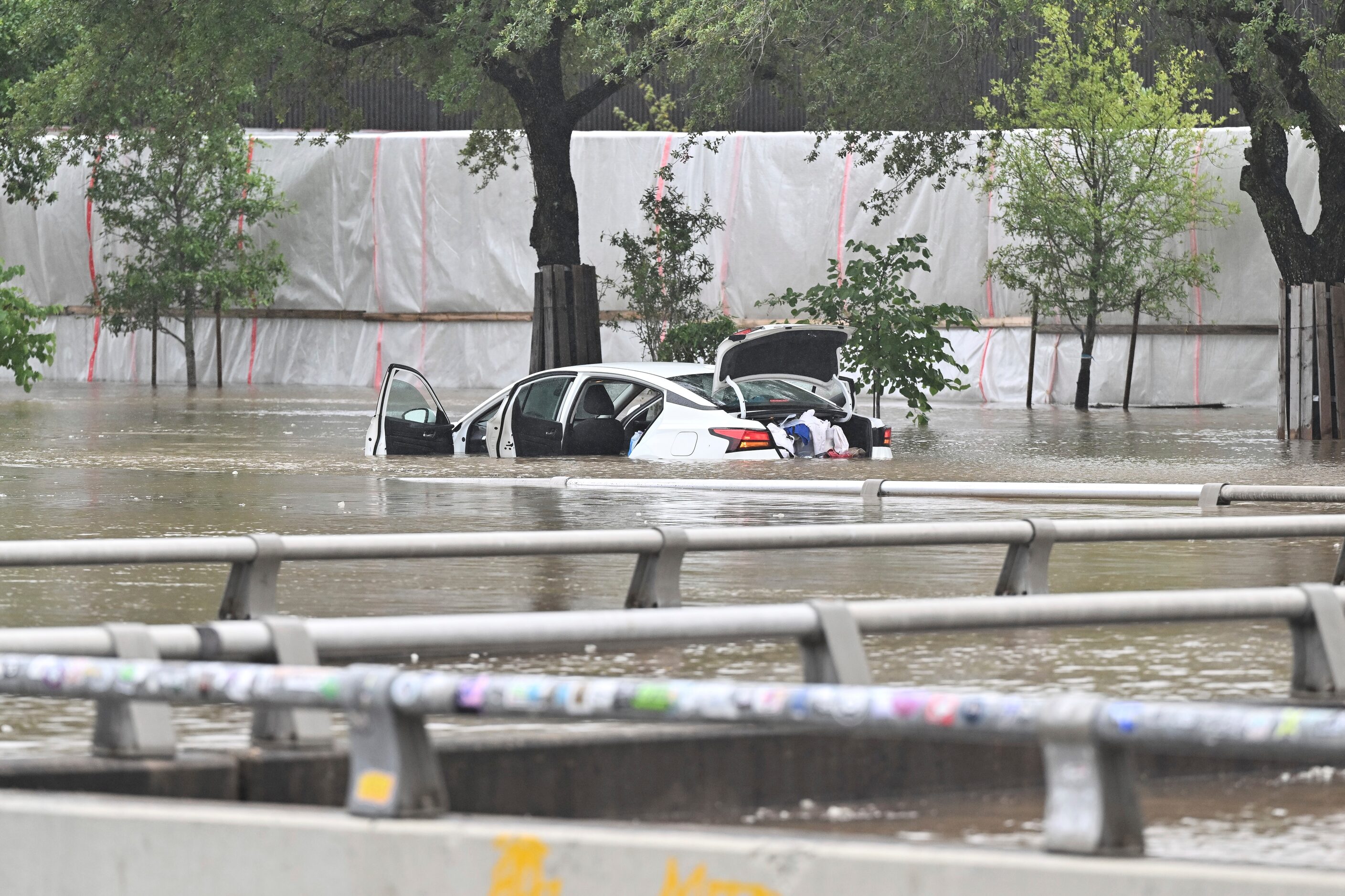 A vehicle is stranded in high waters on a flooded Allen Parkway in Houston, on Monday, July...