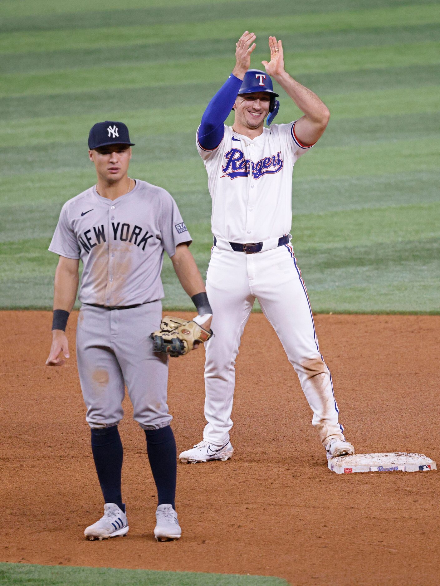 Texas Rangers outfielder Wyatt Langford (36) claps hands after safely getting to the second...